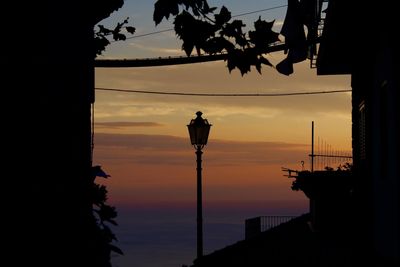 Low angle view of silhouette street light against sky during sunset