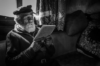 Man reading book while sitting at home