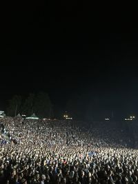 Crowd at music concert against sky at night