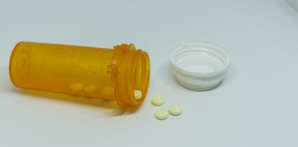 High angle view of yellow bottle on white background