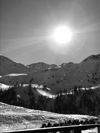 Scenic view of snowcapped mountains against bright sun