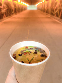 Close-up of hand holding drink on road