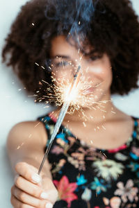 Portrait of smiling woman holding sparkler