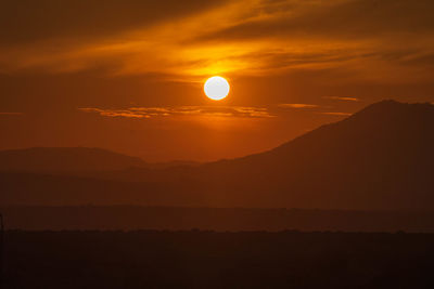 Scenic view of silhouette mountains against sky during sunset