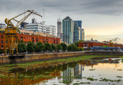 Reflection of buildings in river against sky