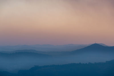 Scenic view of silhouette mountains against sky during sunset