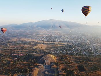 Aerial view of hot air balloons flying in city