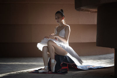 Ballet dancer sitting on stool