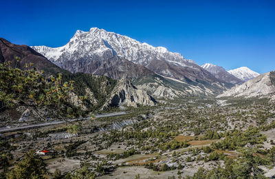 Scenic view of snowcapped mountains against clear blue sky