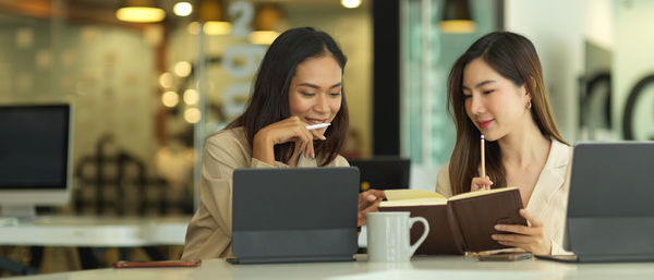 Beautiful businesswomen using computer while sitting in office