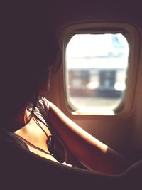 Woman looking through window in train