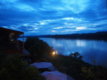 Scenic view of lake by buildings against sky at dusk