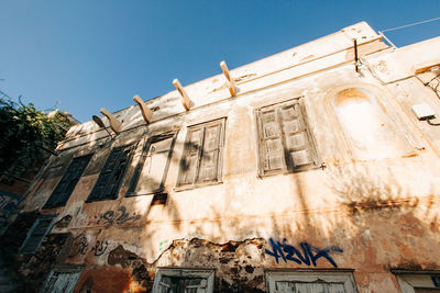 Low angle view of old building against clear blue sky