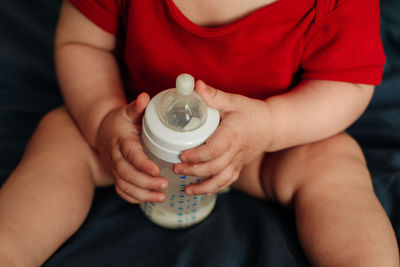 Midsection of woman holding bottle