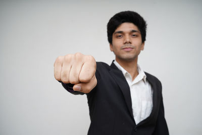 Portrait of young man standing against white background