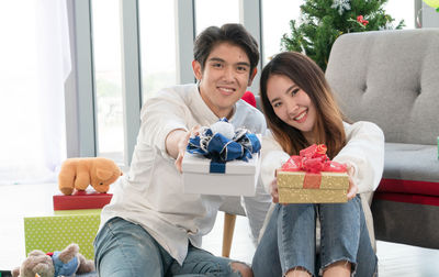 Portrait of happy friends sitting on sofa