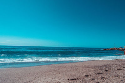 Scenic view of sea against clear blue sky