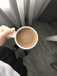 Low section of woman holding coffee cup