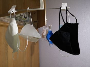 Close-up of shoes hanging against wall at home