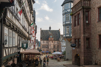 People on street amidst buildings in city