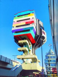 Low angle view of multi colored built structure against blue sky
