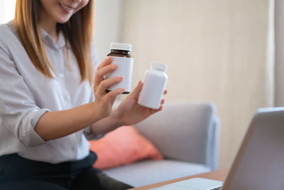 Midsection of woman holding coffee cup