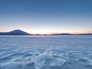 Frozen lake. footprints across snow covered lake. winter season greeting card background