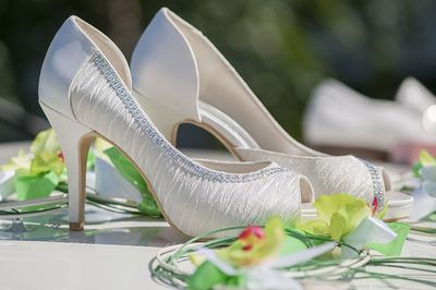 Close-up of stilettoes amidst artificial flower decoration on car roof