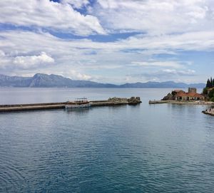 Scenic view of lake by buildings against sky