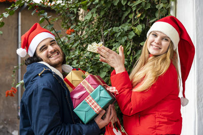 Christmas shopping time. happy young couple busy with christmas gifts outside the home. 