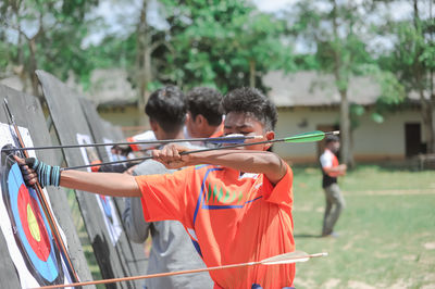 Rear view of men holding umbrella