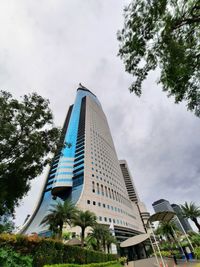 Low angle view of modern building against cloudy sky