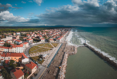 High angle view of townscape by sea against sky