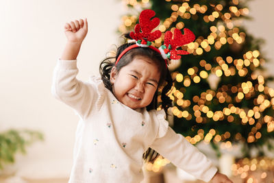 Portrait of an asian emotional little girl child having fun on christmas holiday in decorated house