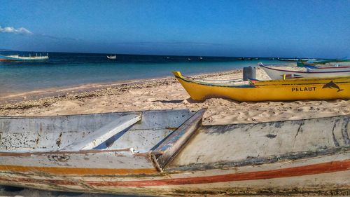 Boats moored on sea shore against sky