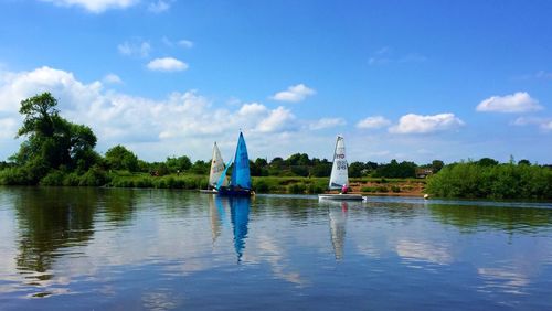 Sailboats in lake against sky