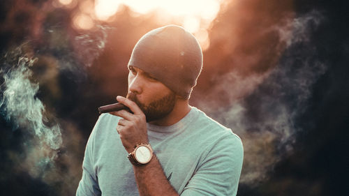 Close-up of man smoking cigar standing outdoors