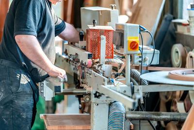 Midsection of man working at workshop