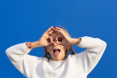 Portrait of young woman against blue sky