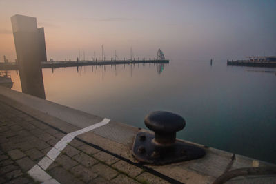 Pier over lake against sky during sunset