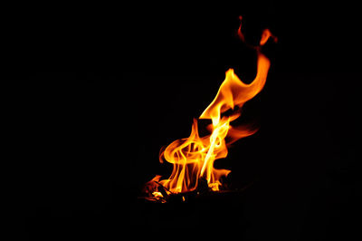 Close-up of burning candle in dark room