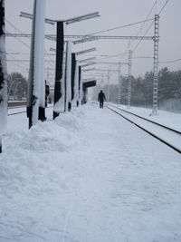 People on snow covered landscape against sky