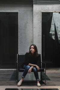 Portrait of young woman sitting on seat