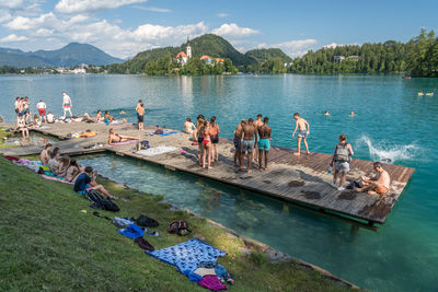 People on lake against sky