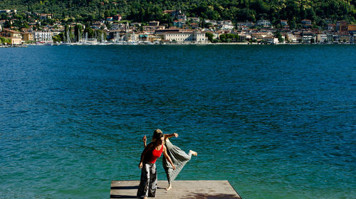 Women on pier against sea in city