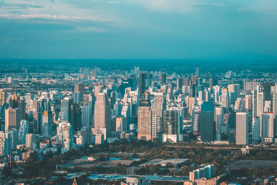 Aerial view of city by sea against sky