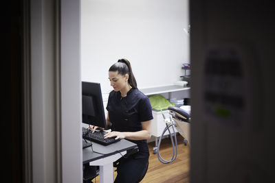 Female dentist using computer in office