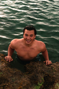 High angle portrait of smiling man swimming in sea