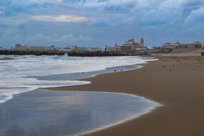 Scenic view of beach against sky in city