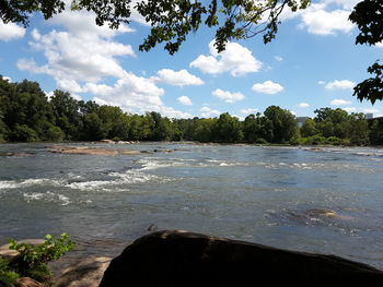 Scenic view of river against cloudy sky